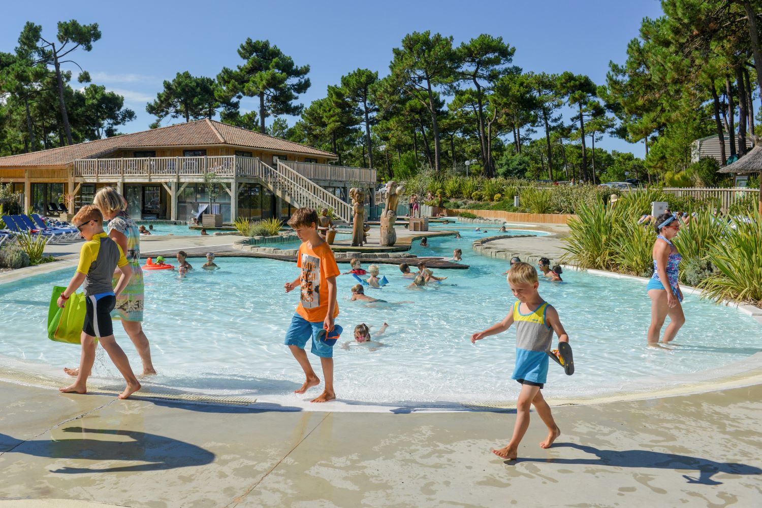 Famille devant la piscine du camping Les Grands Pins à Lacanau